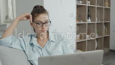 疲惫的十几岁的学生女孩在家里使用笔记本电脑，在笔记本上打字，准<strong>备考</strong>试或家庭作业